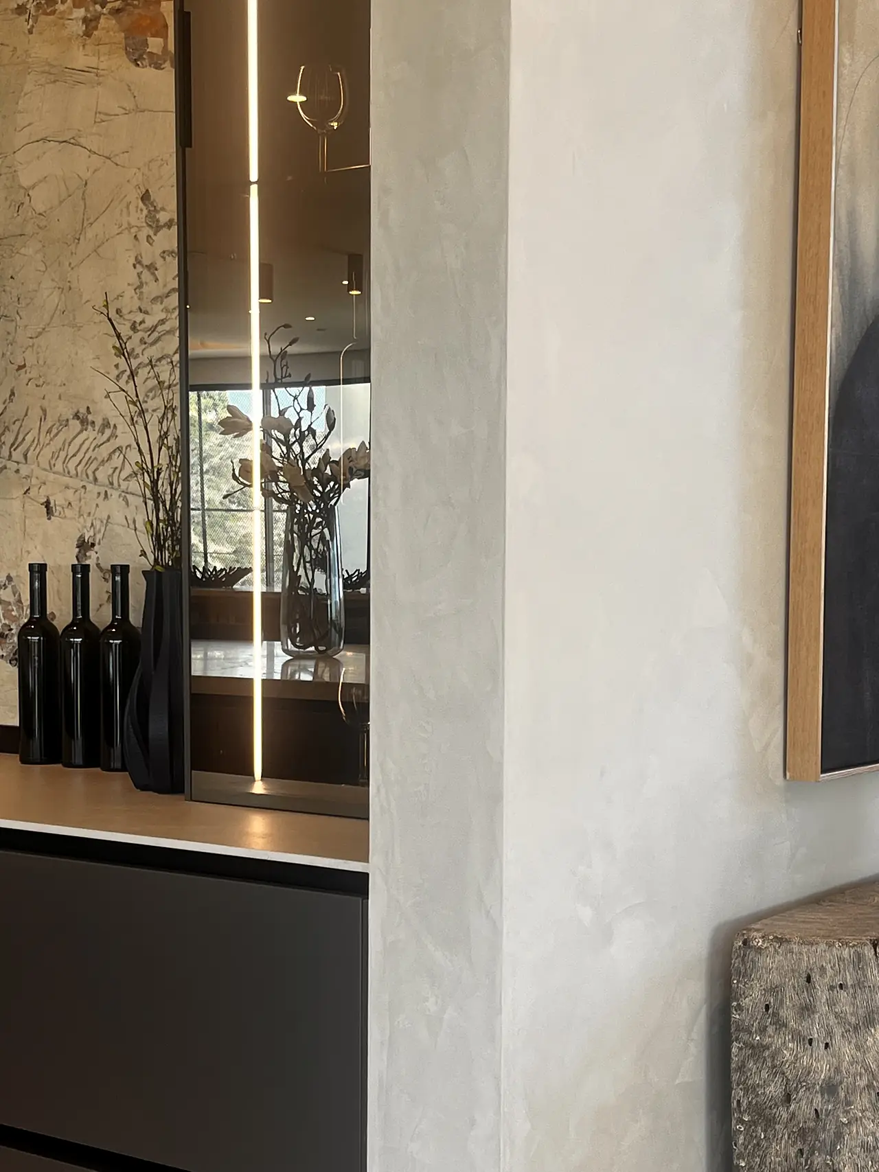 Custom texture plaster wall beside a lit wine display in a Los Angeles home