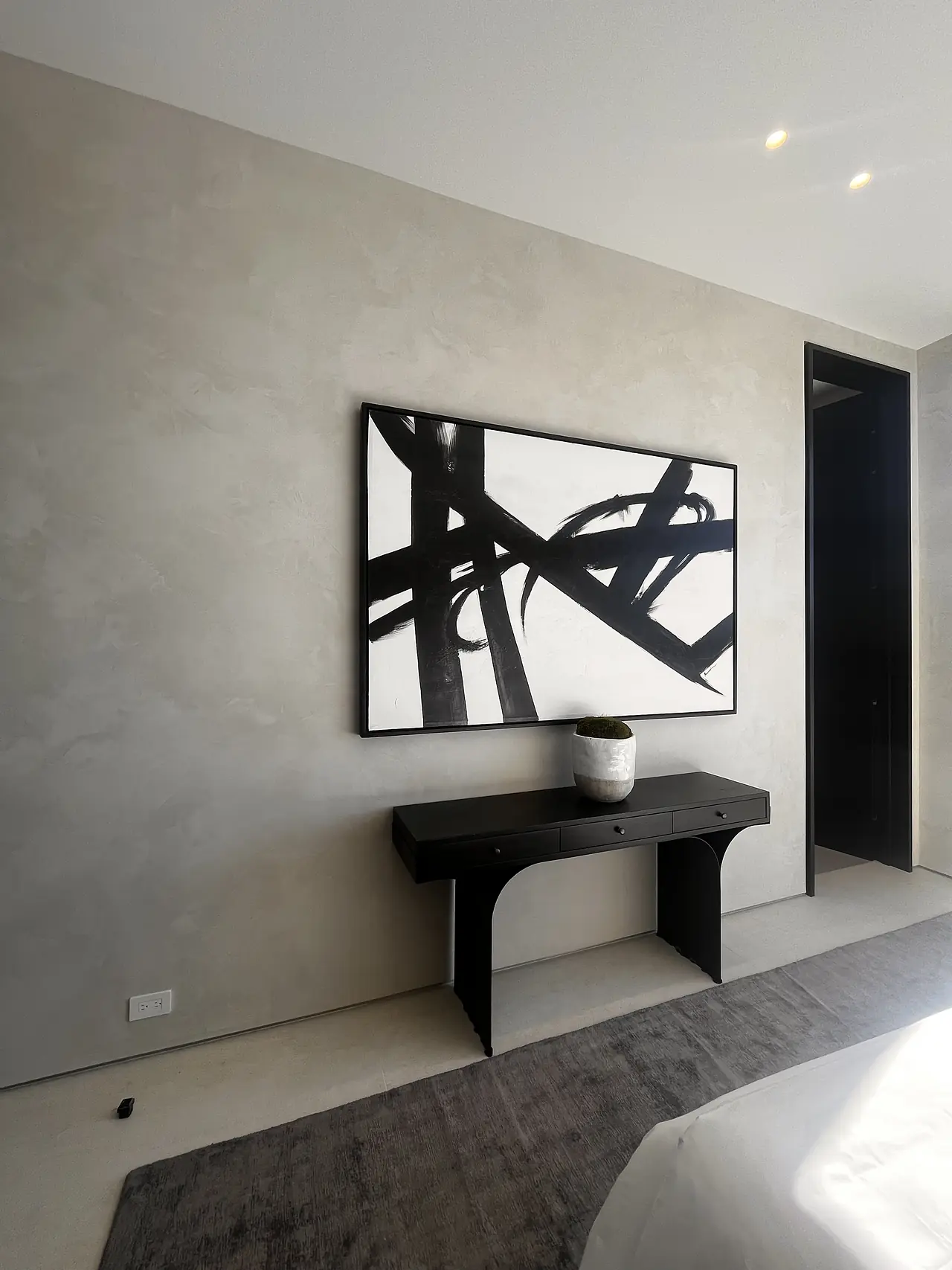Limewash wall finish behind a black console in a Los Angeles living room