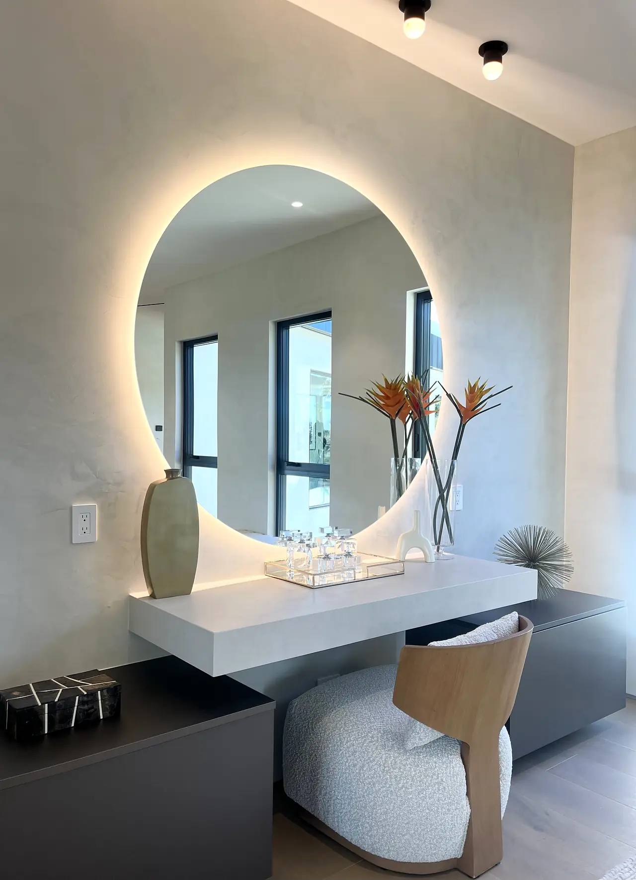 Bathroom with plaster walls and a round backlit mirror