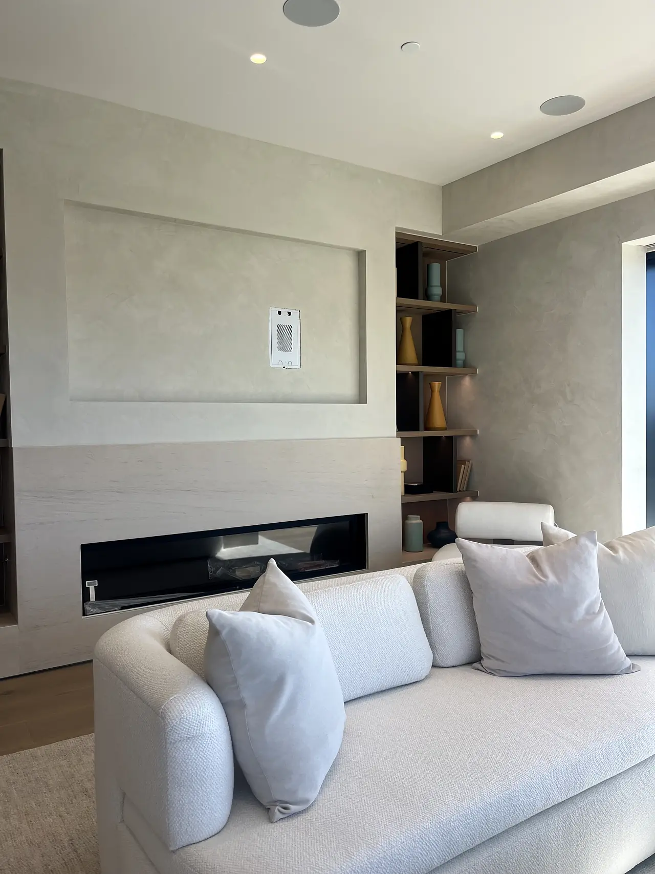 Plaster fireplace accent wall in a bright living room