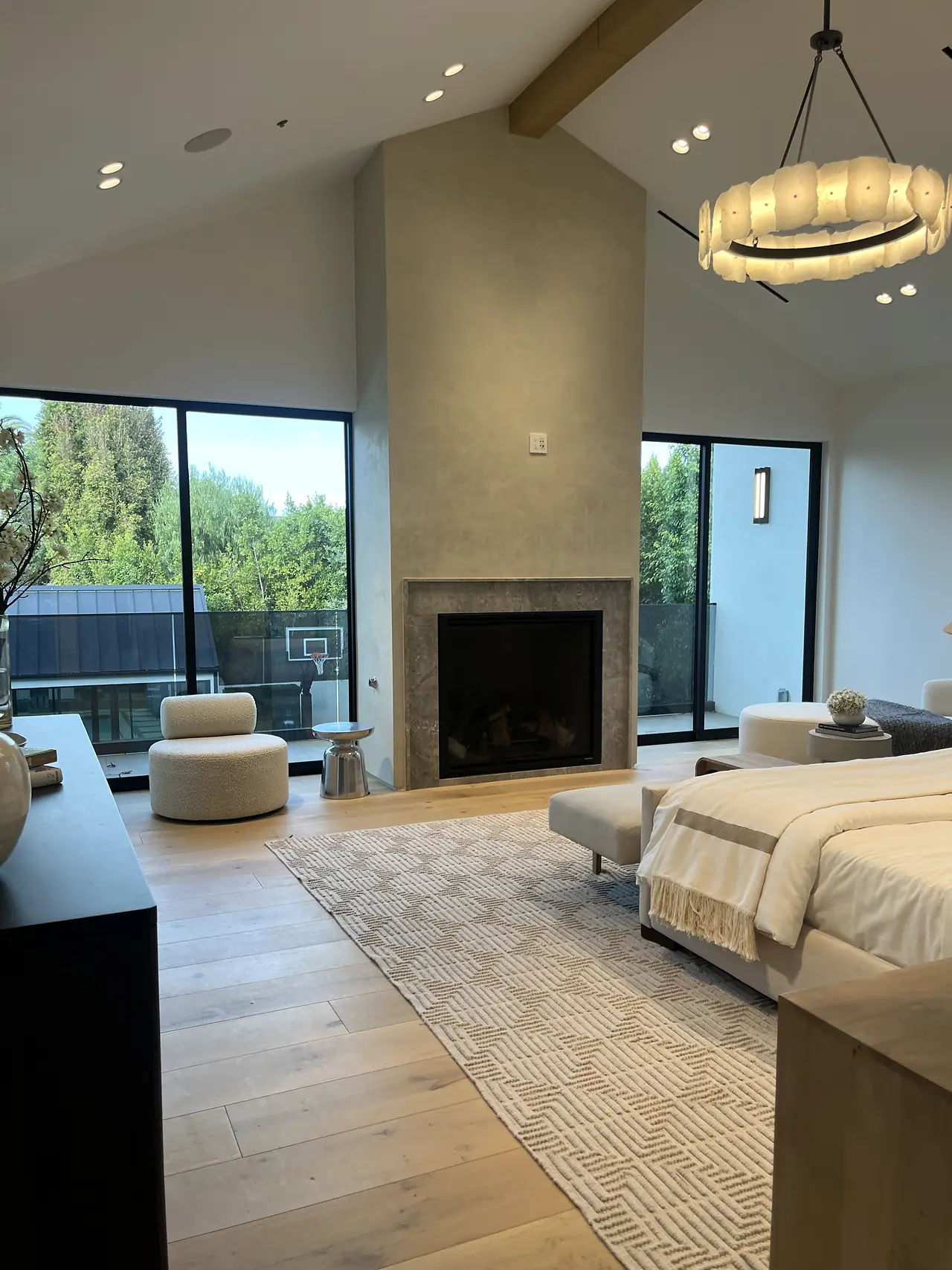Plaster fireplace chimney rising to a vaulted ceiling in a bedroom