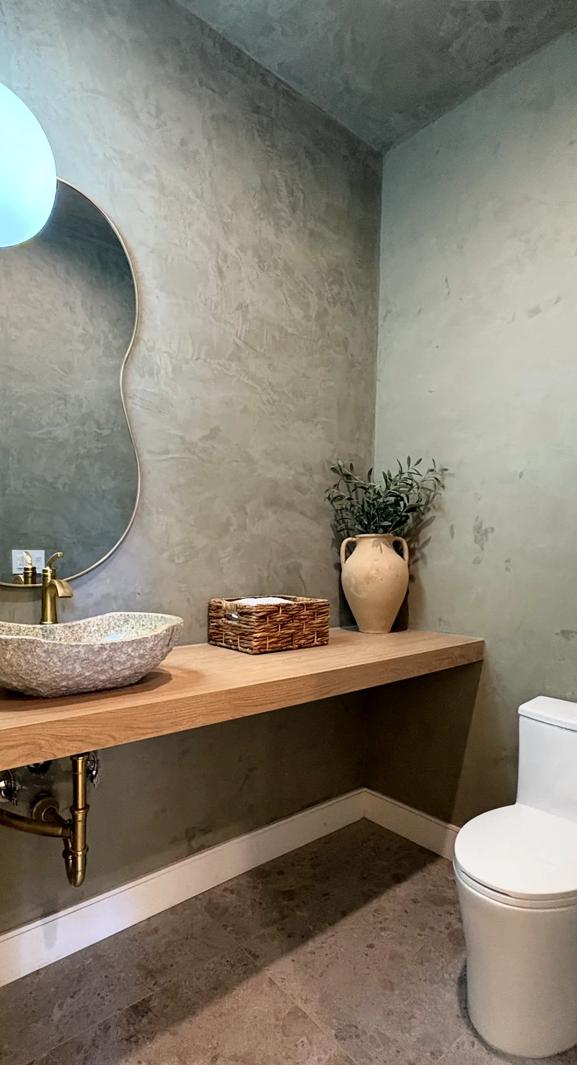 Powder room with plaster walls and a stone vessel sink