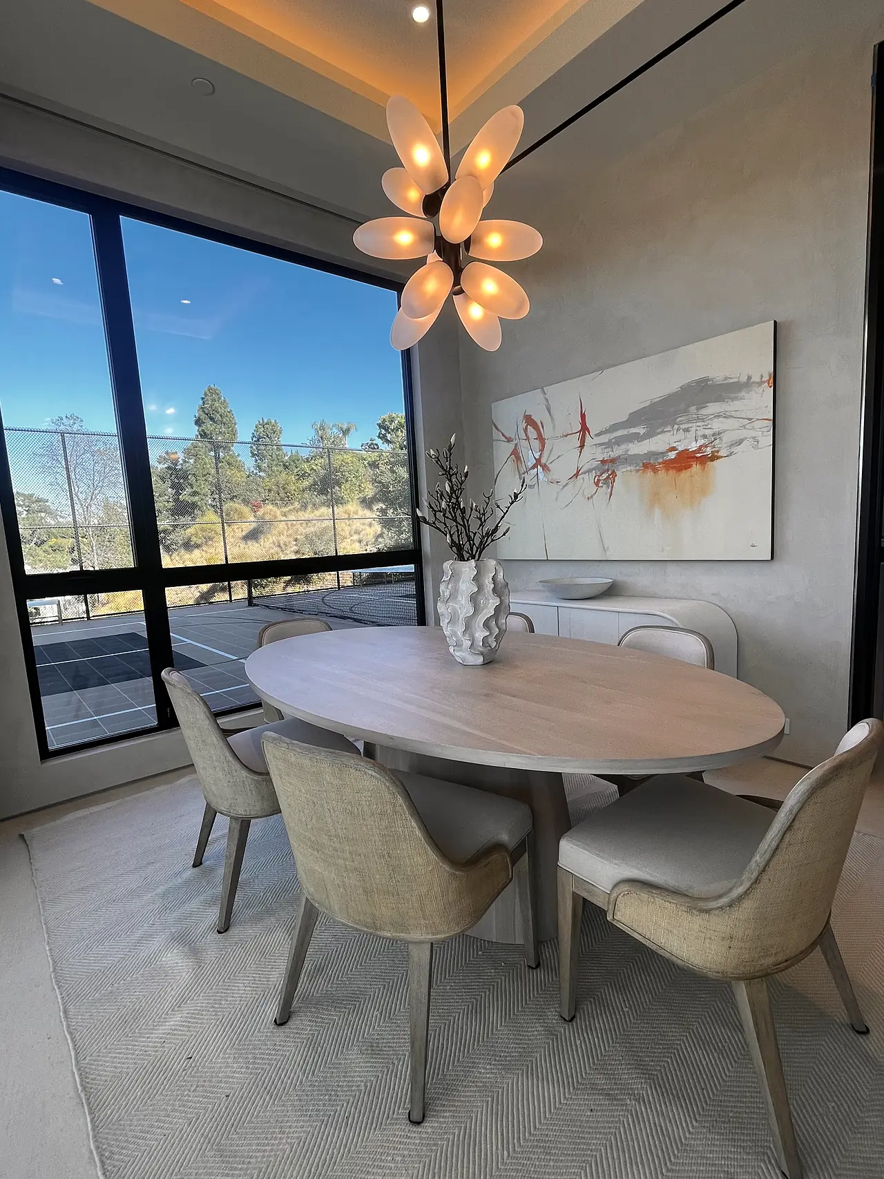 Dining room with plaster walls and a sculptural chandelier