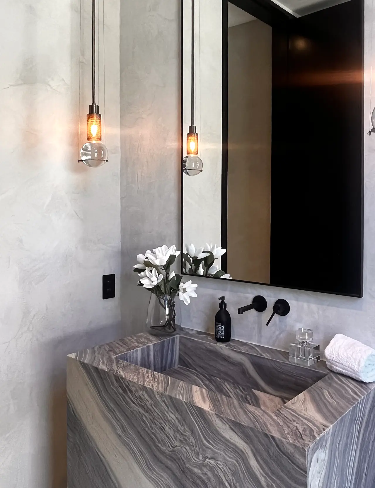 Venetian plaster powder room wall with glass pendant lights in a Los Angeles home